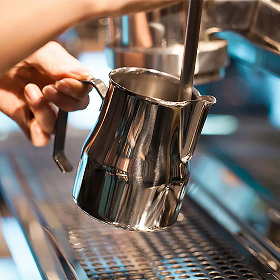Metal pitcher being used in a coffee-making process