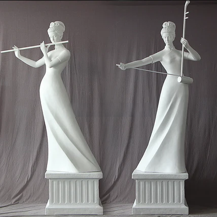 Two white marble statues of women holding musical instruments against a gray curtain background