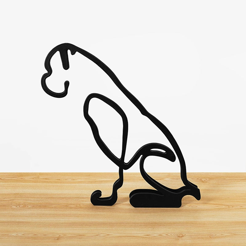 Black metal panther sculpture on a wooden surface with a white background