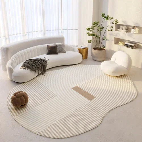 Modern living room with a curved white sofa, round chair, and patterned rug.