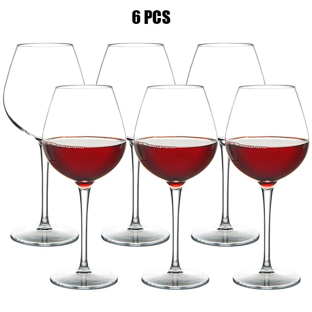 Set of six wine glasses filled with red wine on a white background