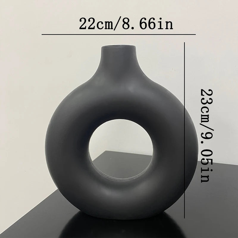 Black vase with circular design on a light gray background, measurements: (D)22cm x (H)23cm