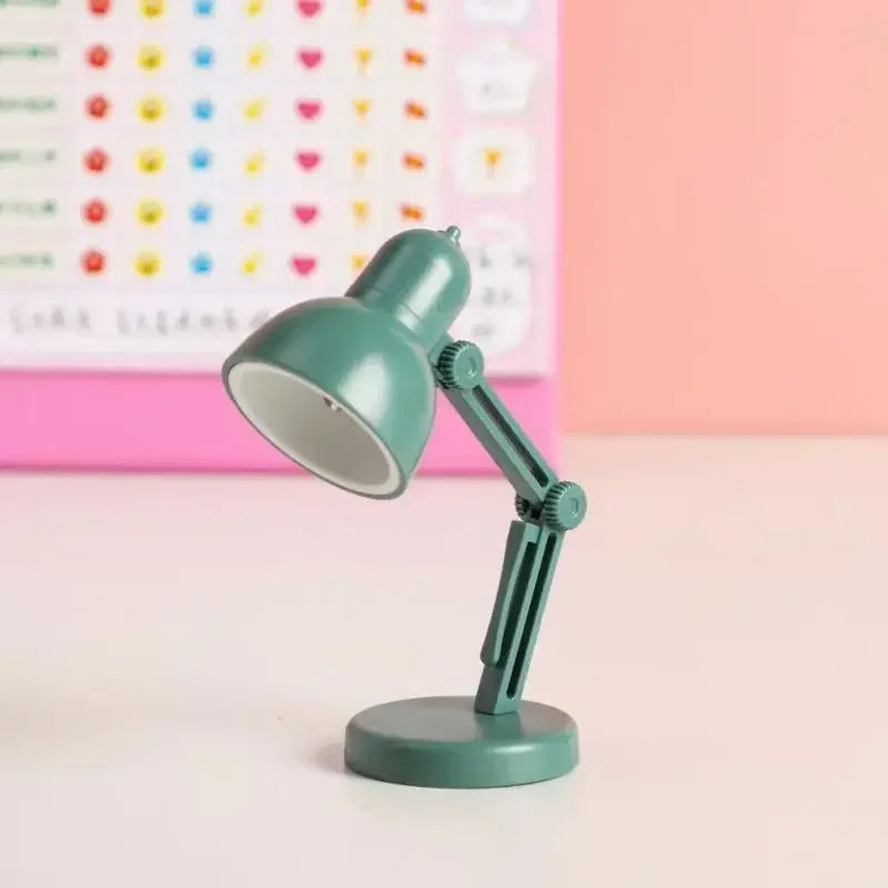 Green desk lamp on a white surface with a colorful polka dot pattern in the background