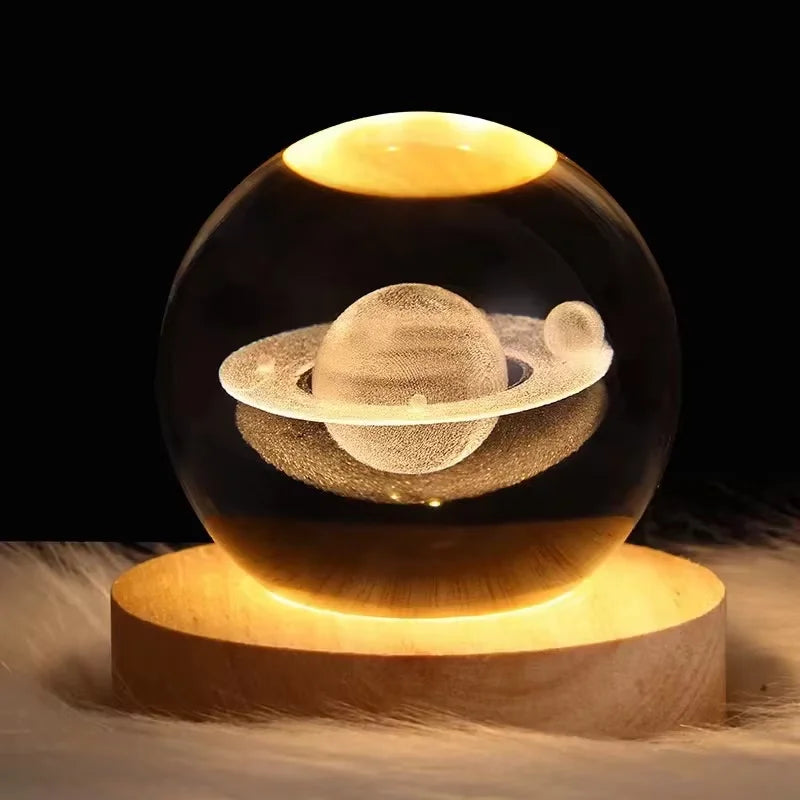 Glass sphere with a 3D Saturn model on a wooden base against a dark background