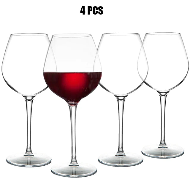 Four wine glasses with red wine, one of which is filled to the brim, on a white background.