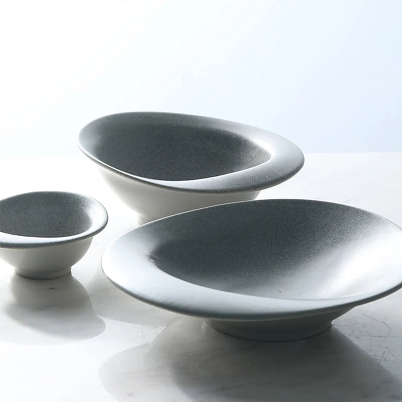 Three ceramic bowls of varying sizes on a light surface with a white background