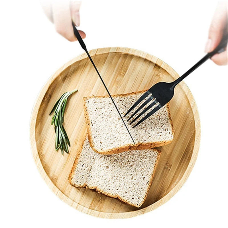 Two slices of bread on a wooden plate with a fork and knife, on a white background.
