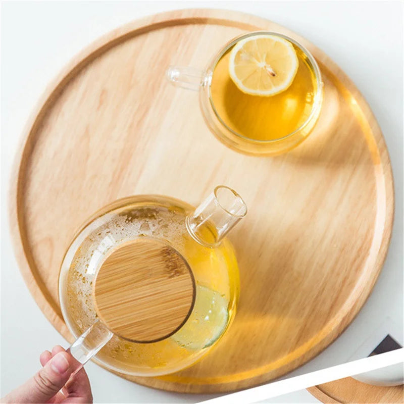 Two glass cups with lemon slices on a wooden tray