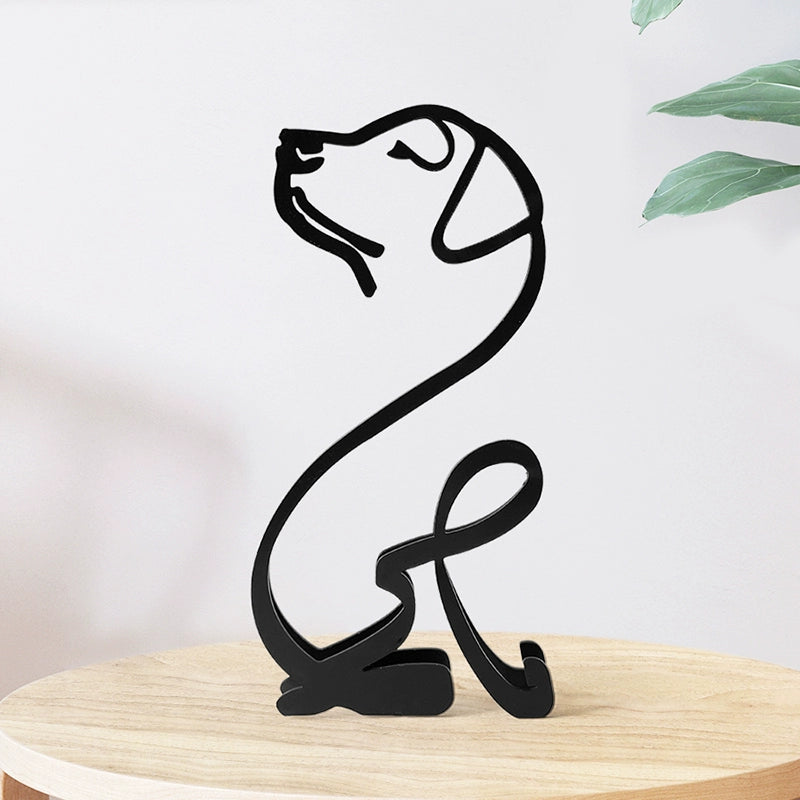 Black metal sculpture of a dog on a wooden stand with a light background