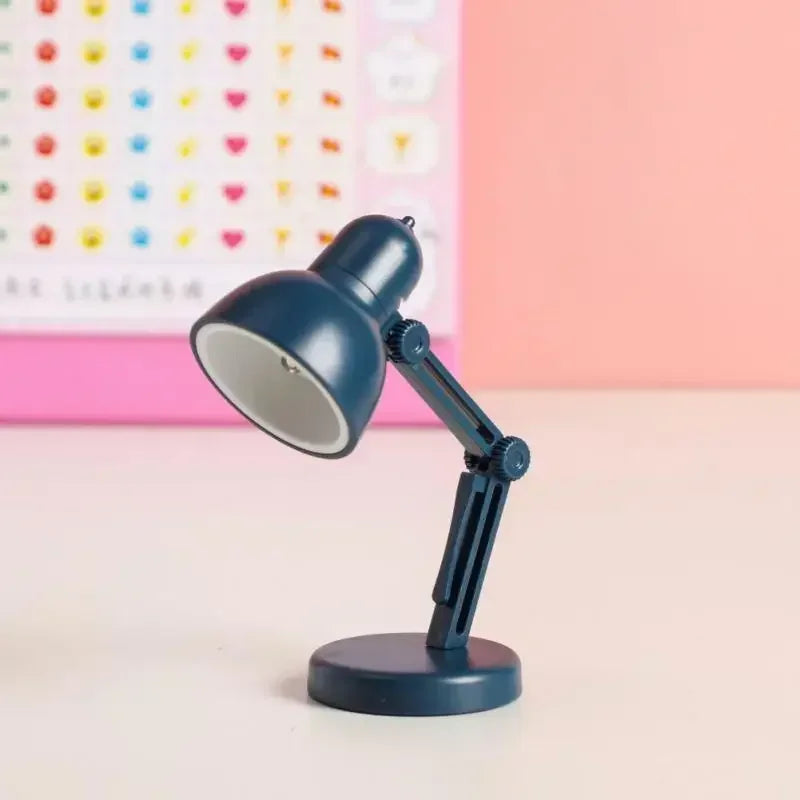 Blue desk lamp on a light pink surface with a colorful heart-patterned wall in the background