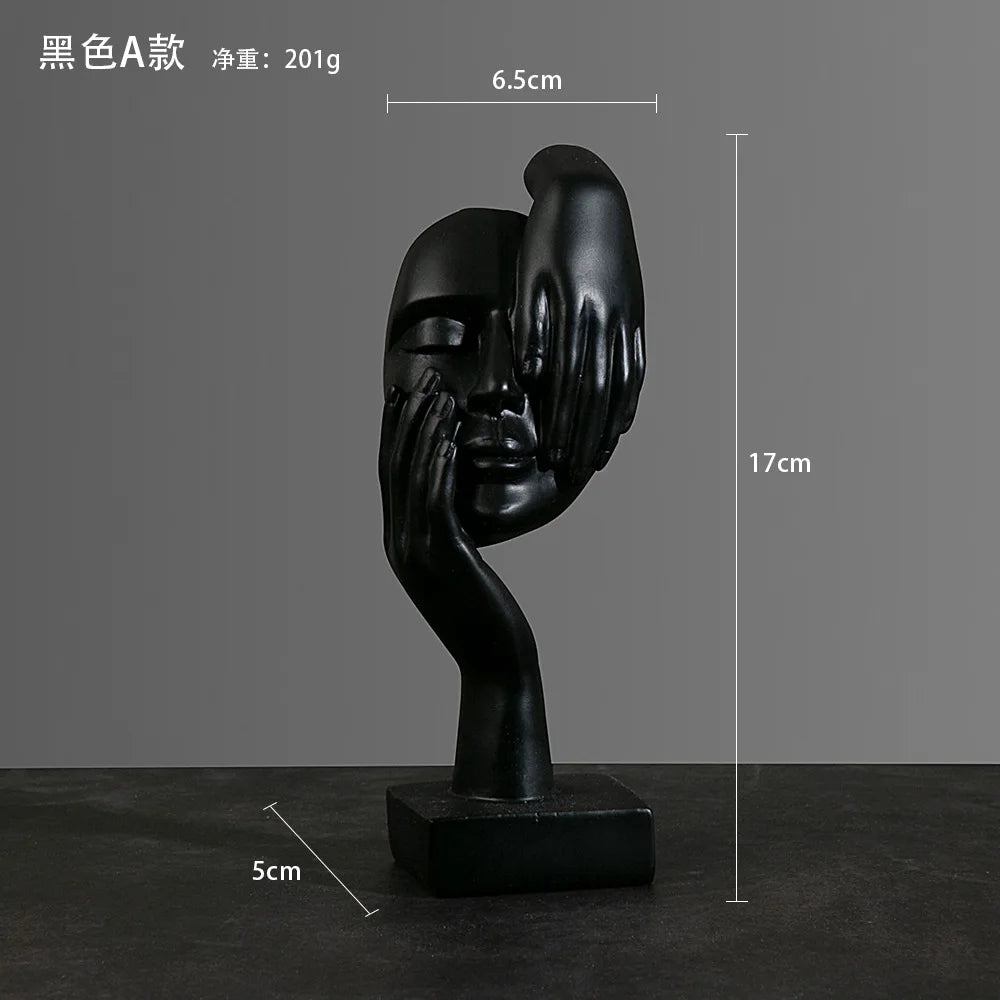 Black sculpture of a face being held from up and down by hands with measurements: 5cm x 17cm x 6.5cm