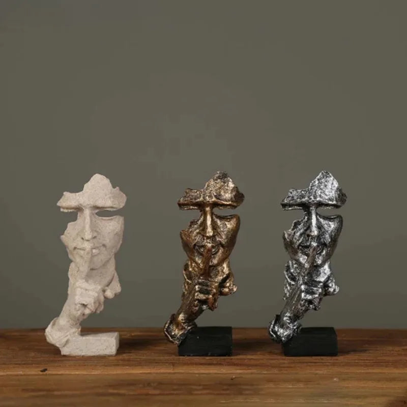 Three figurines on a wooden surface with a dark background