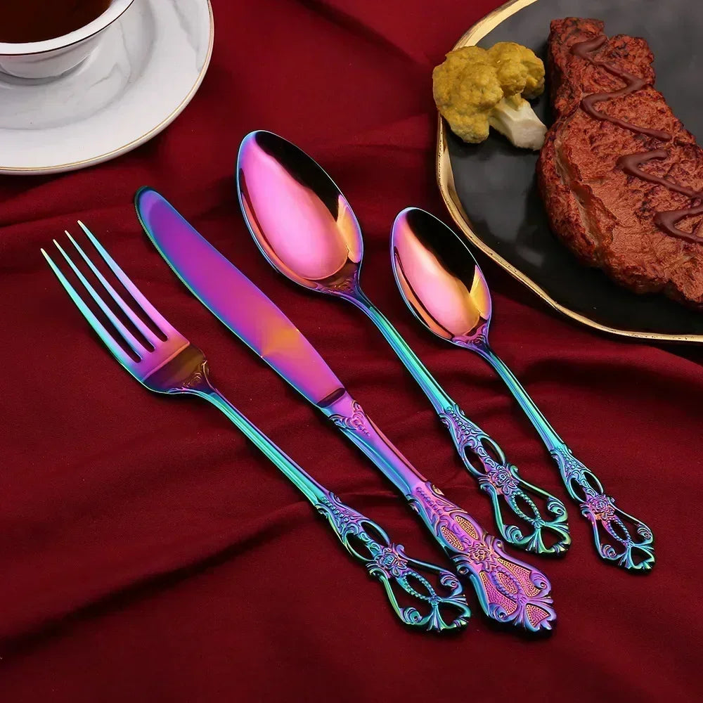 Colorful cutlery set on a red surface with a plate of food in the background