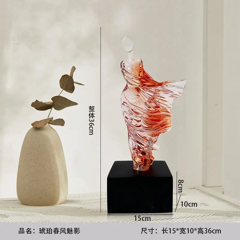 Decorative resin sculpture on a black base with measurements, next to a beige vase. Height 36cm, 10cm x 15cm base