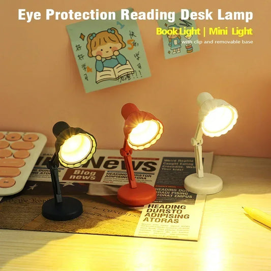 Three reading light lamps on a table with a newspaper underneath.
