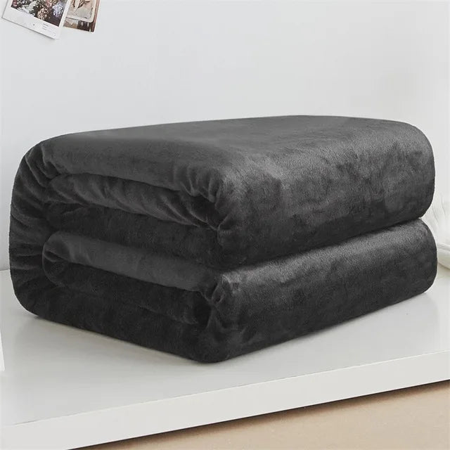 Folded dark gray comforter on a white surface