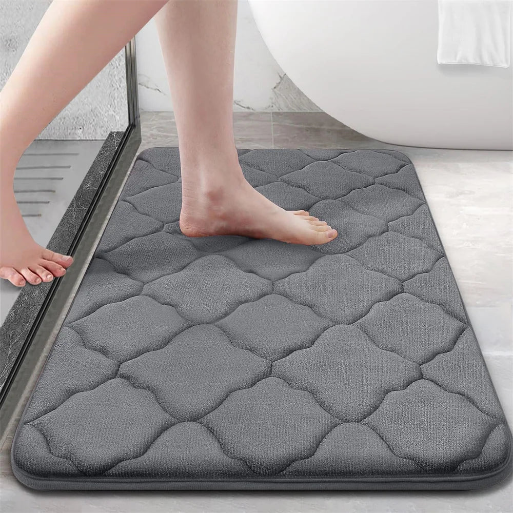 Person stepping onto a gray bath mat in a bathroom setting