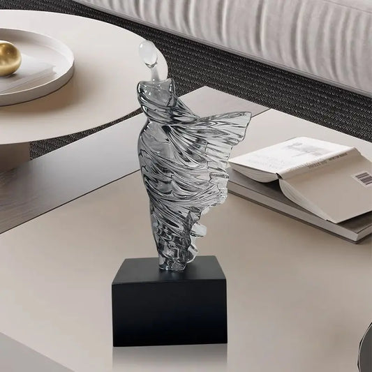 Decorative resin sculpture on a black base with books in the background