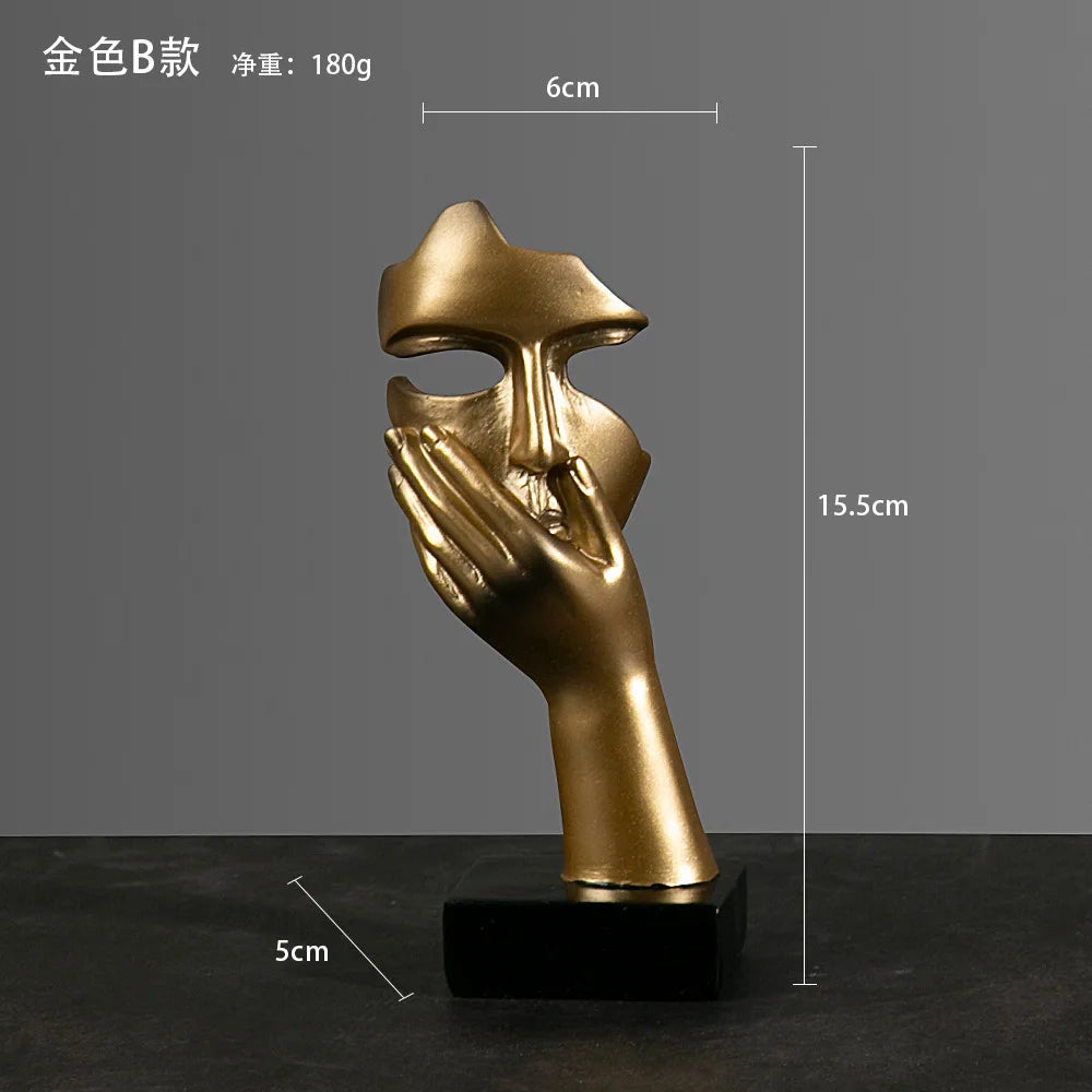 Gold sculpture with hand covering its mouth, placed on a black base against a gray background. Measurements:  5cm x 15.5cm x 6cm