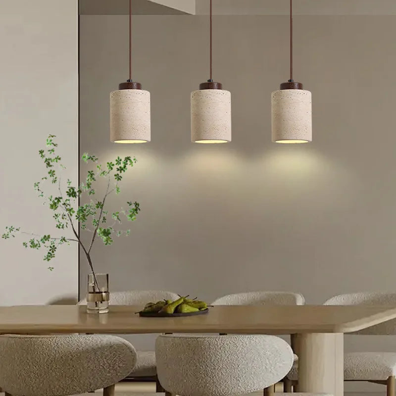 Dining room with pendant lights, table, and chairs.