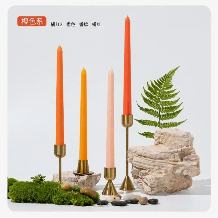 Set of tall candles in orange with decorative elements on a light gray background