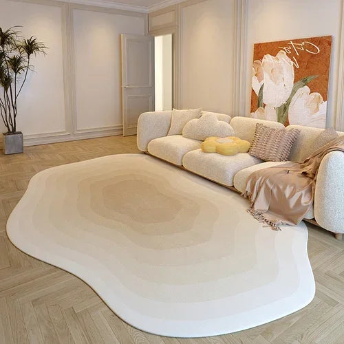 Modern living room with a large white rug, beige sofa, and decorative wall art.