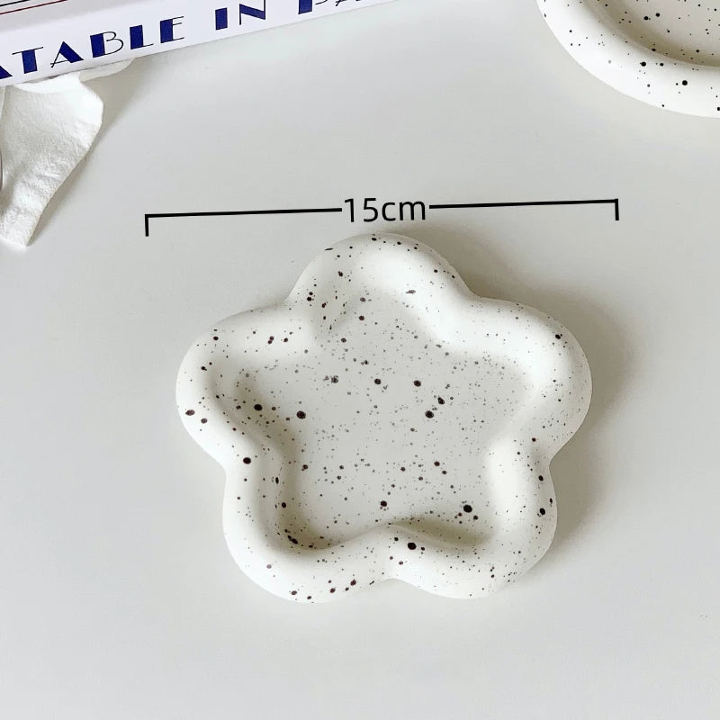 Speckled ceramic dish on a white surface with measurements: 15cm
