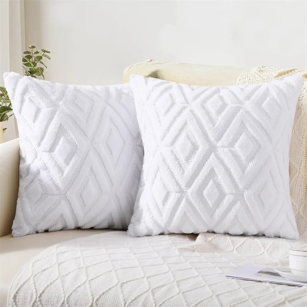 Two white textured pillows on a beige sofa with a light background