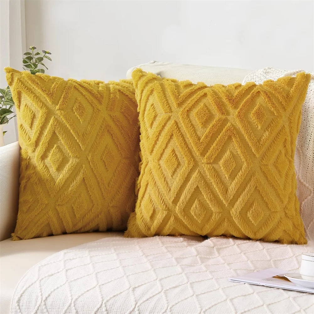 Two yellow textured pillows on a white couch with a light gray wall in the background.