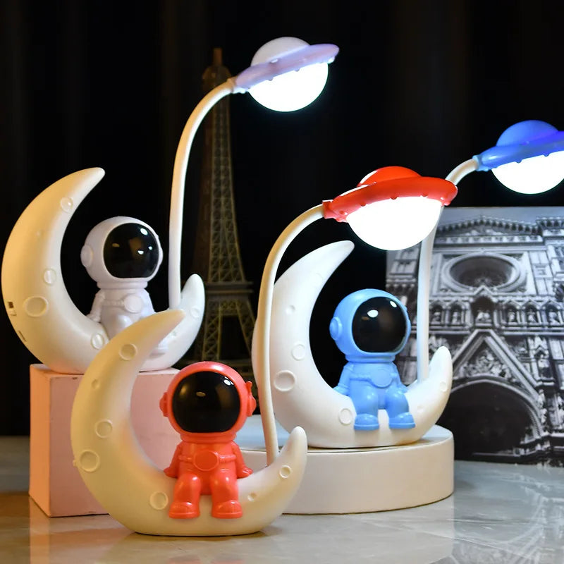 Decorative lamps with astronaut figures on moons against a blurred cityscape background