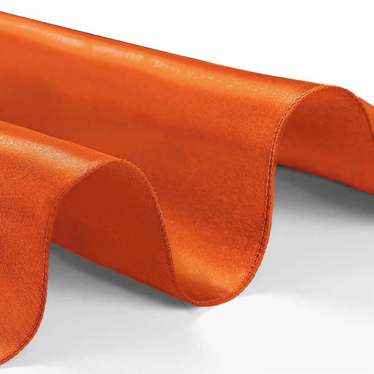 Close-up of orange fabric with a subtle texture on a white background