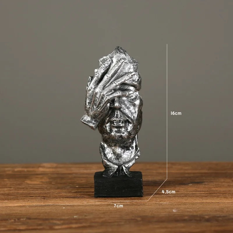 Silver sculpture with facepalm gesture on a gray background. Measurements: 7cm x 16cm x 4.5cm