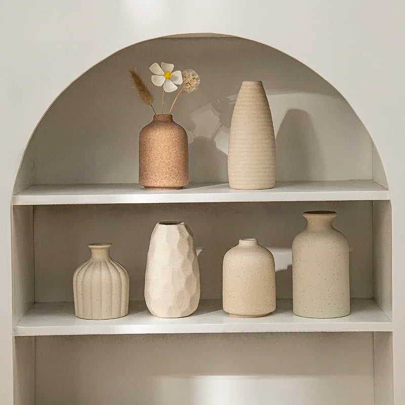 Set of ceramic vases on a shelf with a neutral background