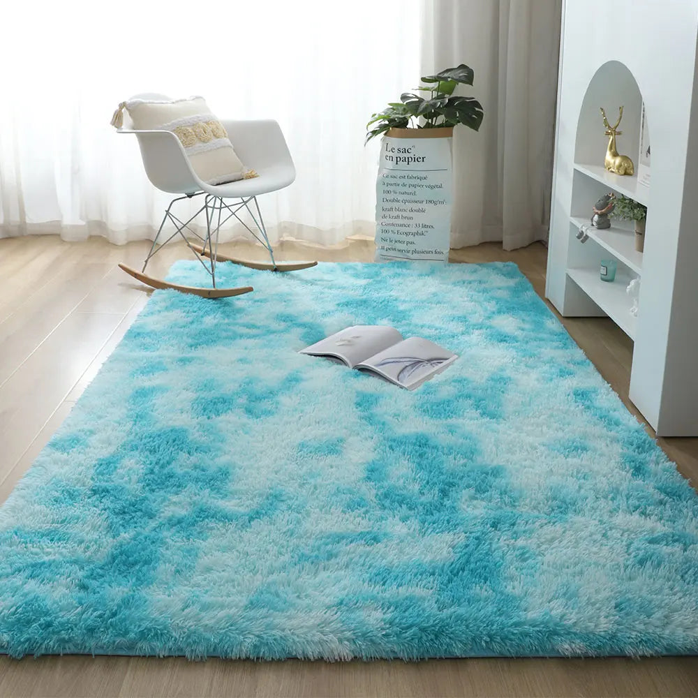 Blue shaggy rug in a room with a rocking chair and white shelves.
