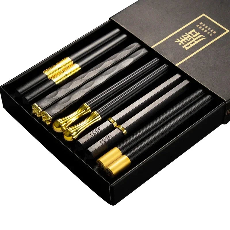 Set of black and gold chopsticks in a black box with gold accents.