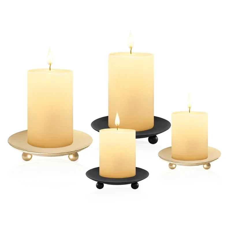 Four candles on decorative holders against a white background