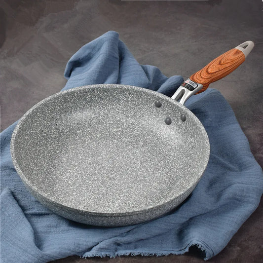 Stone frying pan with wooden handle on a blue cloth