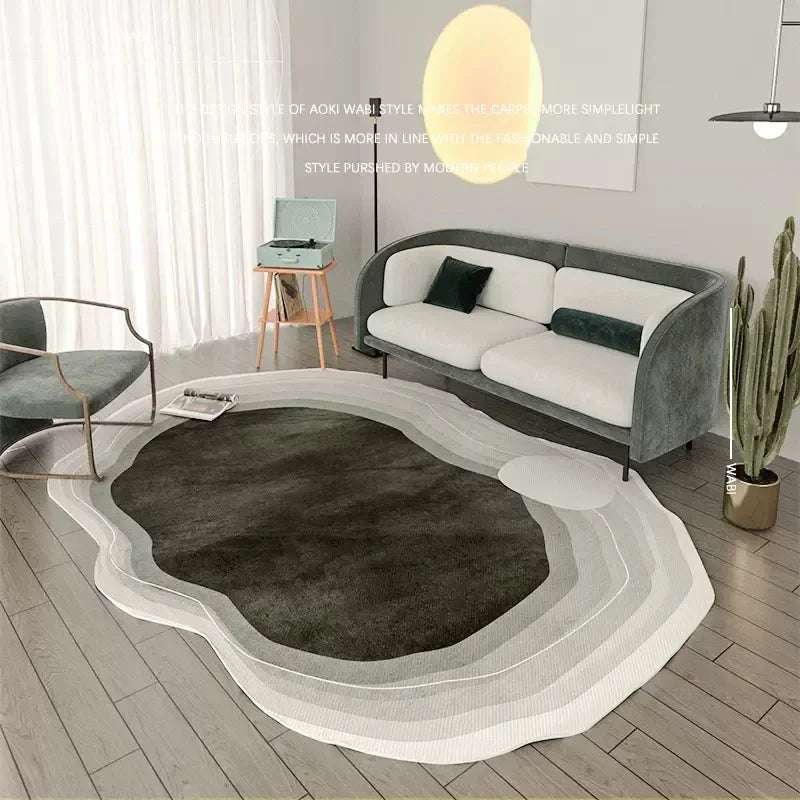 Modern living room with a unique shaped rug and gray sofa.
