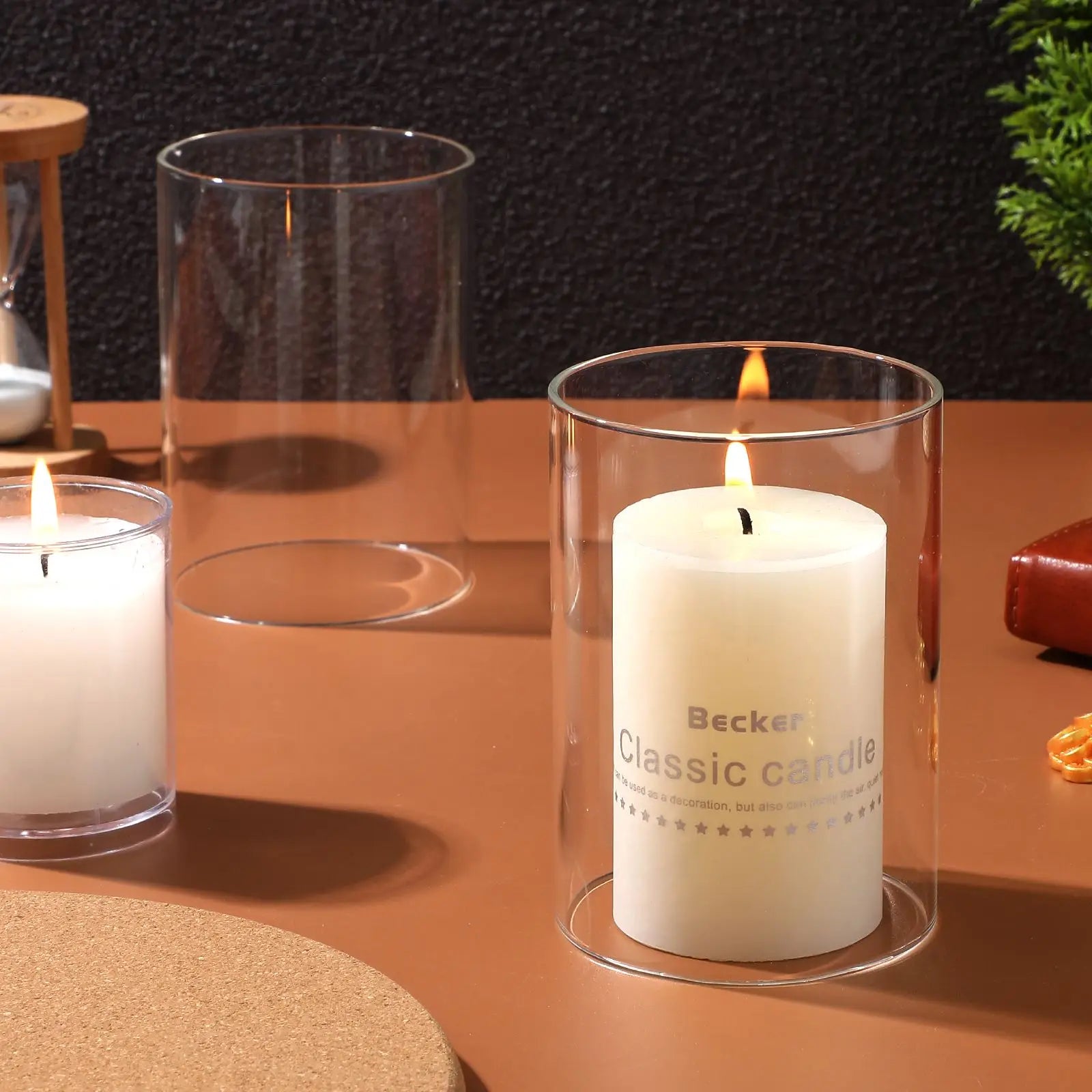 Becker classic candle in a glass holder on a wooden surface with other candles and glass containers.