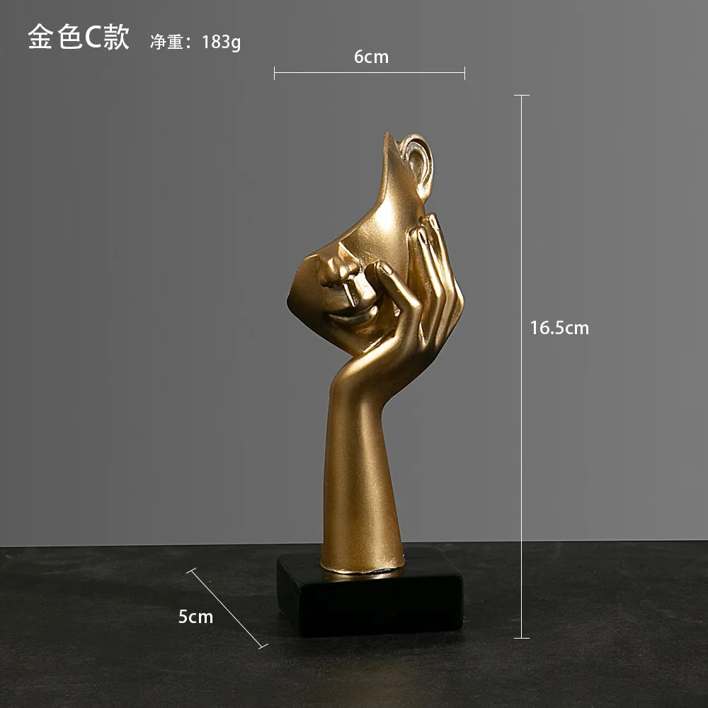 Gold sculpture of a hand hondling a chin on a black base with measurements:  5cm x 16.5cm x 6cm