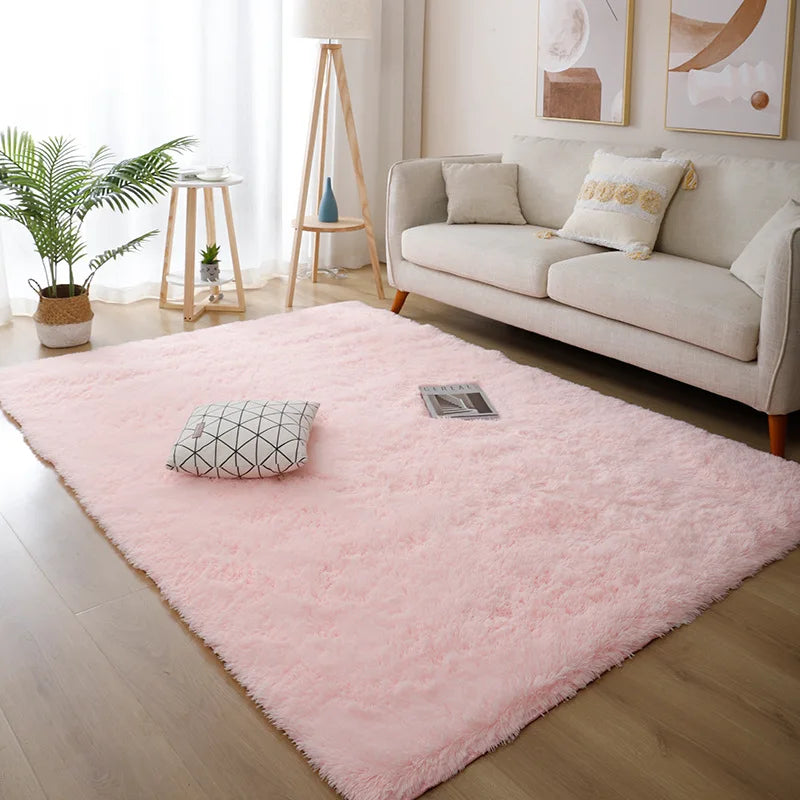 Living room with a pink rug, white sofa, and decorative elements.