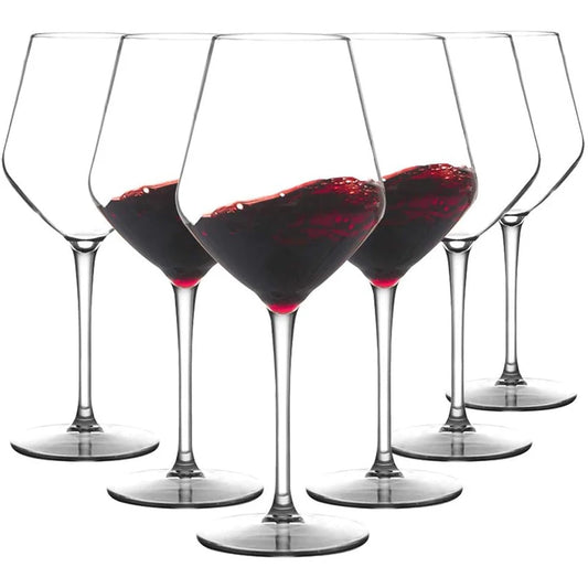 Set of six wine glasses filled with red wine on a white background