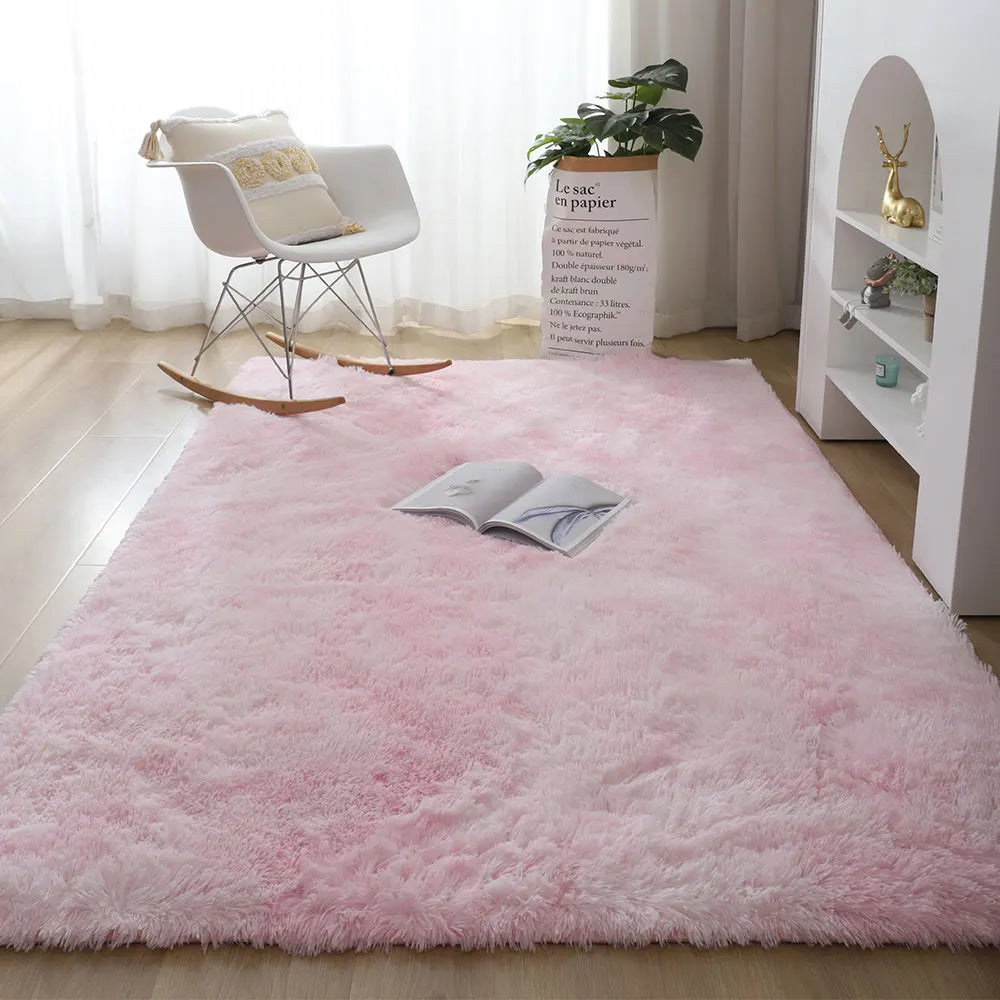 Pink rug in a room with a chair, plant, and book on it
