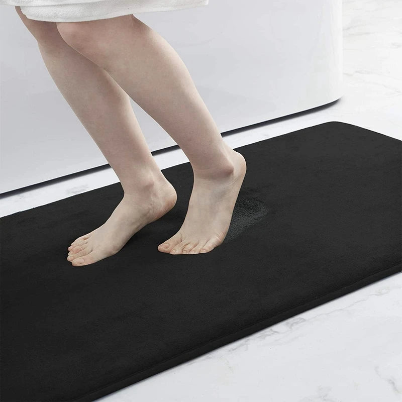 Person stepping onto a black bath mat in a bathroom setting