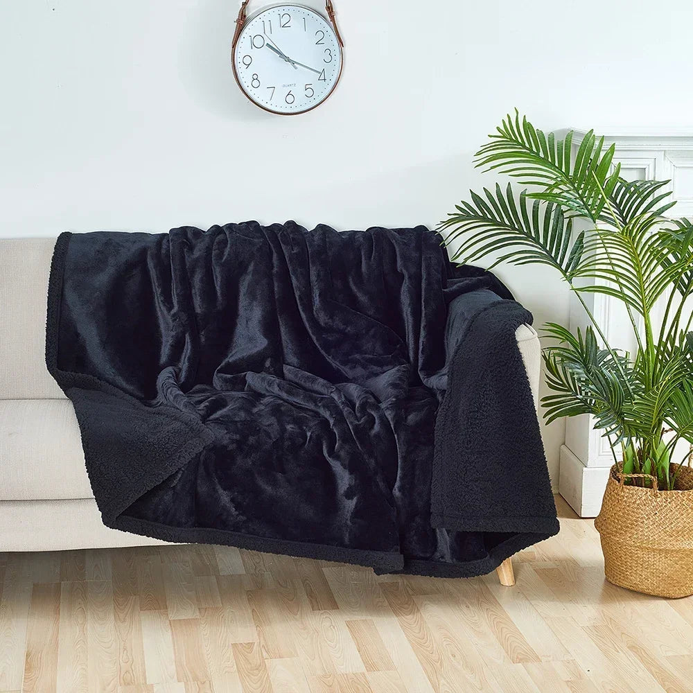Black blanket draped over a chair in a room with a clock and plant