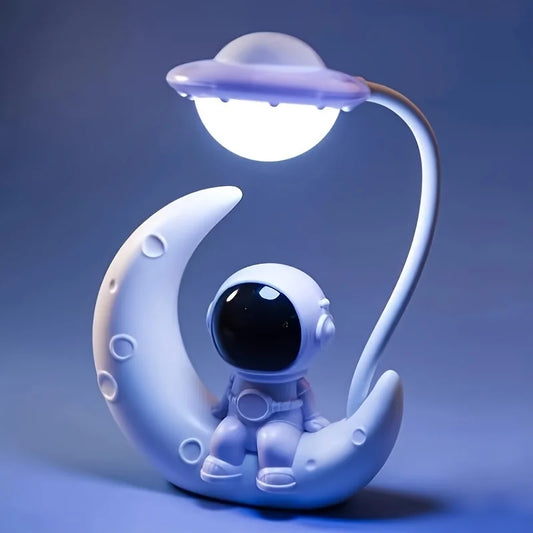 Decorative lamp with an astronaut on a moon and UFO above, on a blue background
