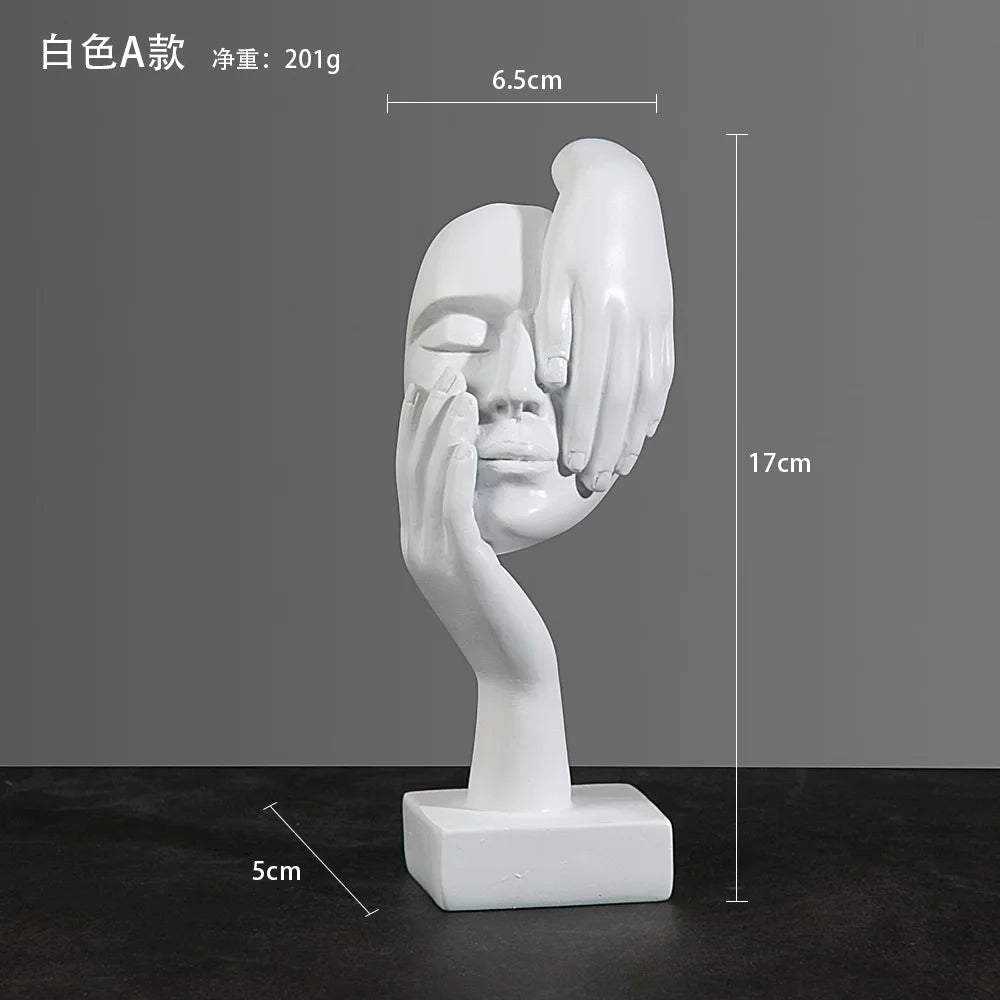 White abstract sculpture of a face and hand on a dark surface with: 5cm x 17cm x 6.5cm