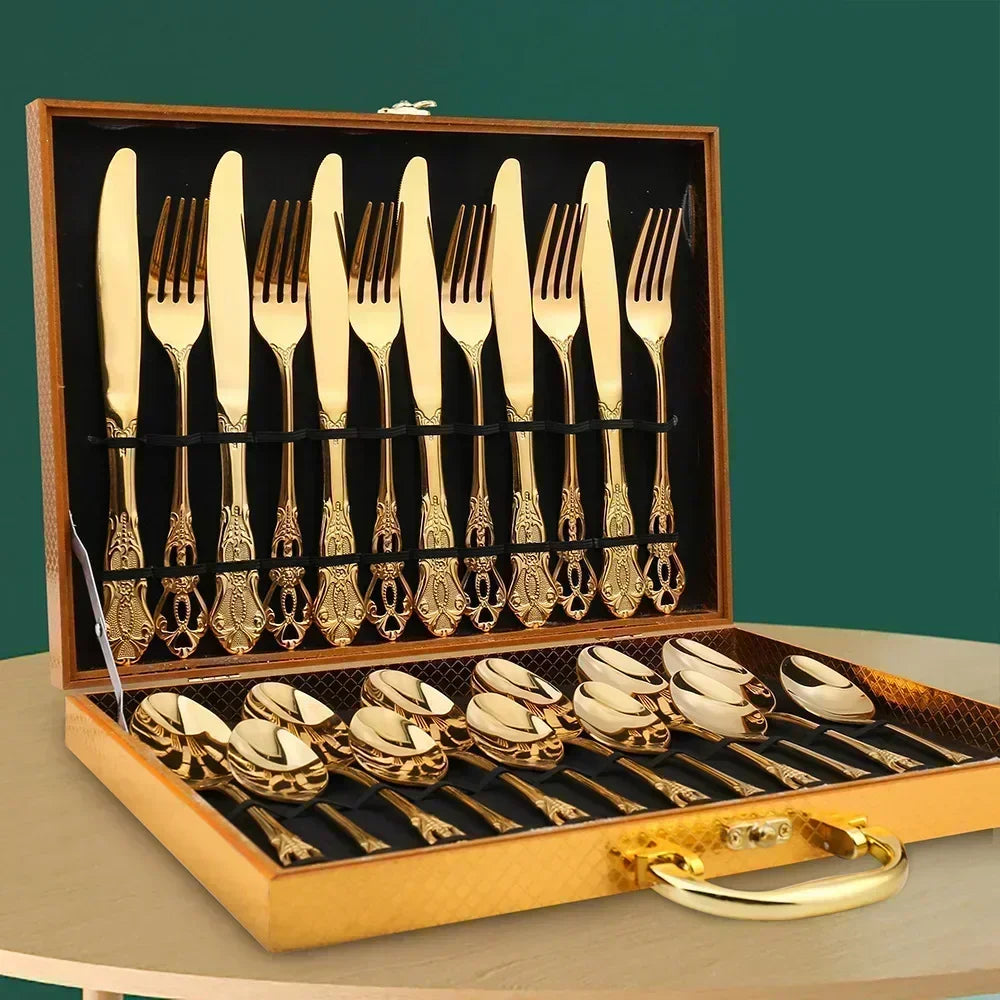 Gold cutlery set in a wooden case on a green background