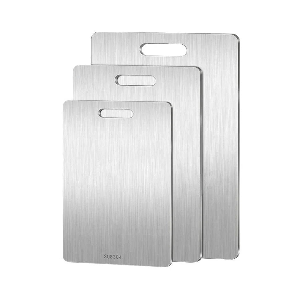 Three stainless steel cutting boards stacked on a white background