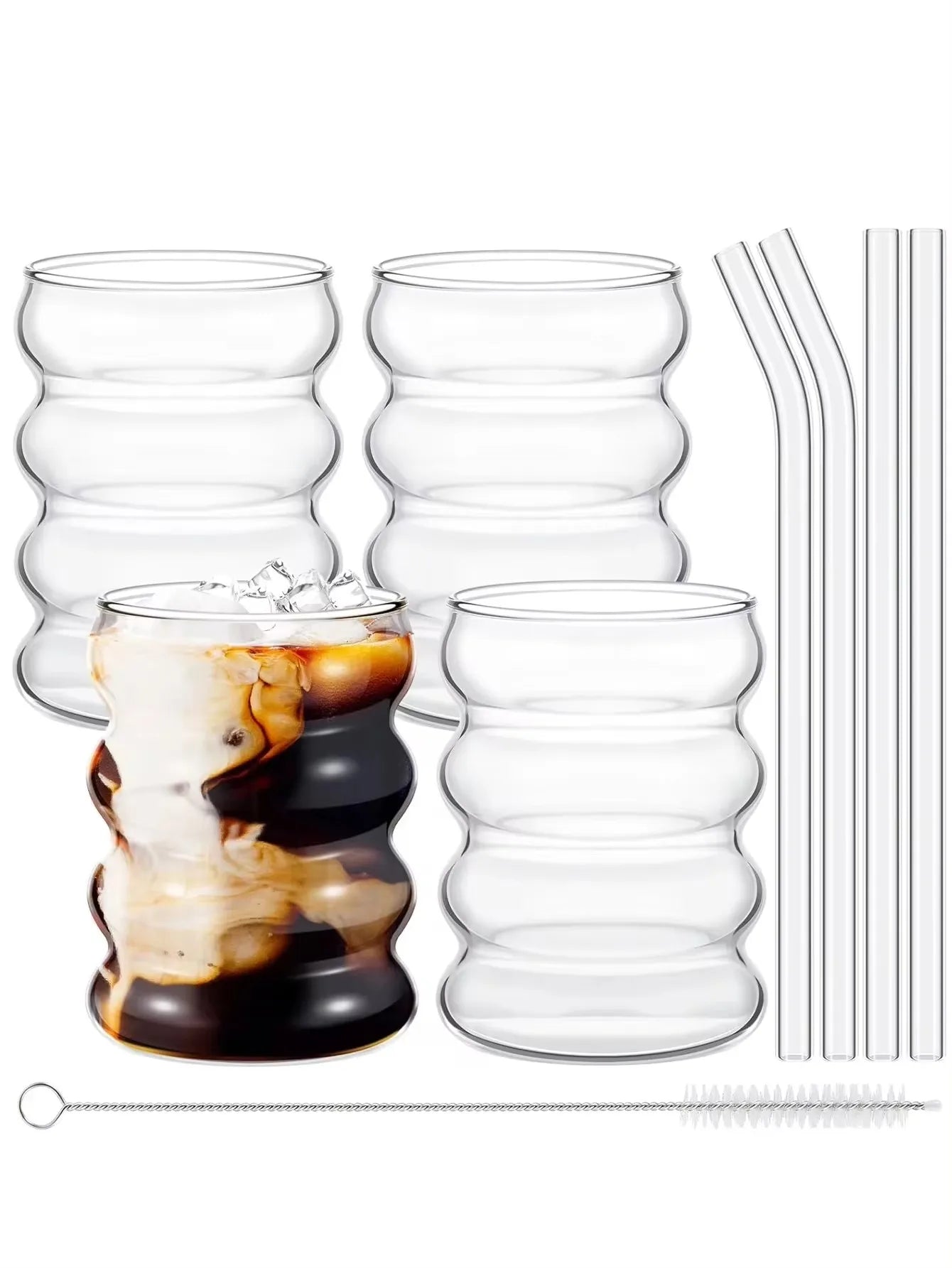 Set of clear glass tumblers with a drink inside, straws, and a stirrer on a white background